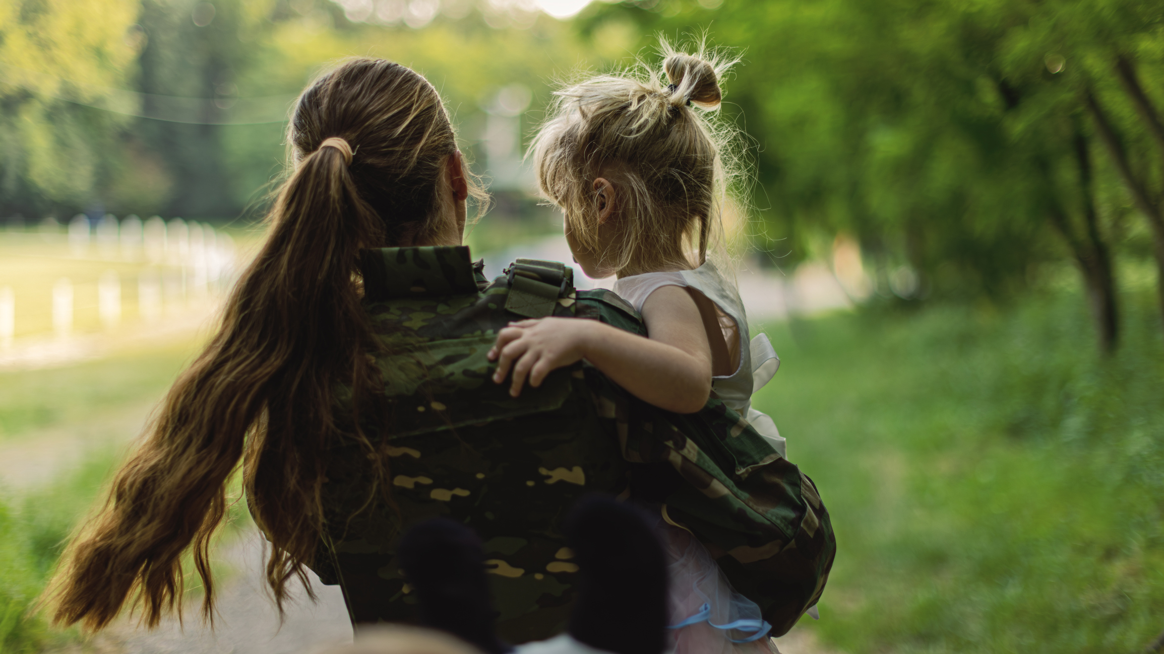 Father in military uniform on tablet with daughter