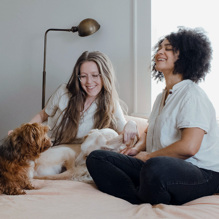 Two women sitting in living room with dogs